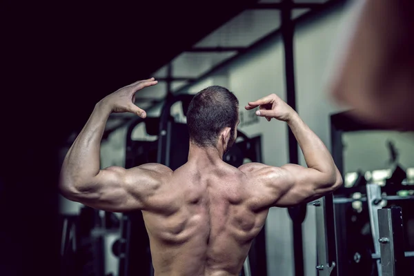 Man showing back in gym — Stock Photo, Image