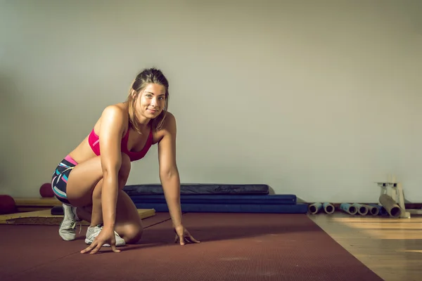 Menina fazendo flexões no ginásio — Fotografia de Stock