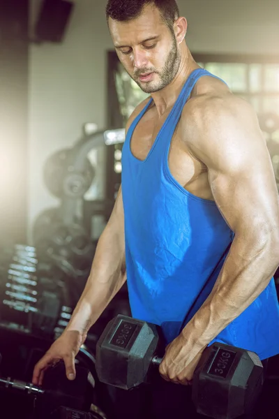 Homme faisant des boucles biceps dans la salle de gym — Photo
