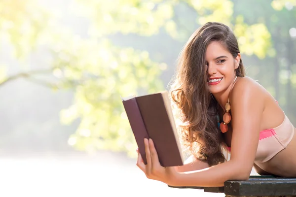 Flicka som läser en bok i parken — Stockfoto