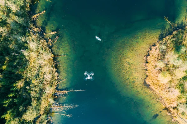 Sup surfing aerial view. Lake in the forest. Drone flying