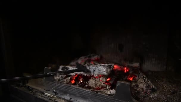 Die roten und dunkelgrauen Kohlen im Kohlenbecken werden mit einer Metallschaufel vermischt. — Stockvideo