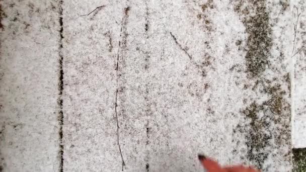 Close-up van het tekenen van een hartvorm met een vinger op verse wintersneeuw op houten treden — Stockvideo