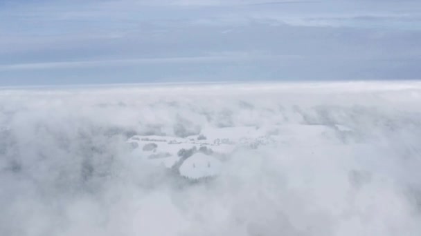 Drone bakåt sköt antenn, snö vit grå grumlig dimmig vinter väder liten by landskap — Stockvideo