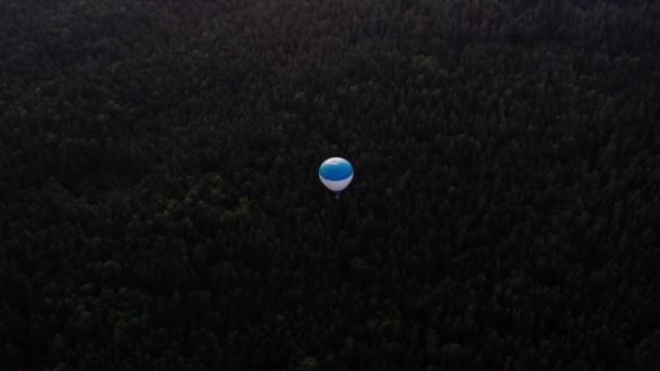 Hete ballon in de lucht boven bos en landschap bij zonsondergang. — Stockvideo