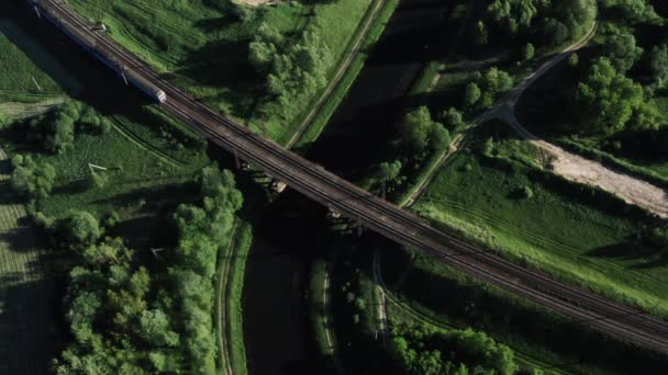 Tåget passerar över bron över ån. Vägen genom en liten by. — Stockvideo