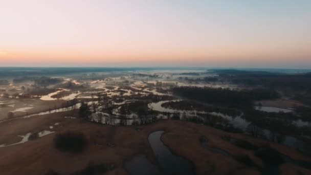 Widok z powietrza krętych rzek w porannej mgle, widok z lotu ptaka rzek o wschodzie słońca, mgła i słońce nad rzekami, widok z lotu ptaka nad bagnem o świcie — Wideo stockowe
