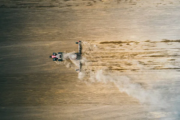 Vista aérea del suelo de labranza del campo de cosecha de tractores. pluma de polvo detrás del tractor, impresionante paisaje agrícola — Foto de Stock