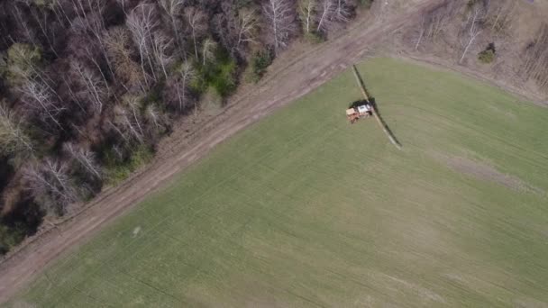 Fertilizante de pulverização de trator em grande campo verde. Vista aérea de lavoura trator agrícola e pulverização no campo. — Vídeo de Stock