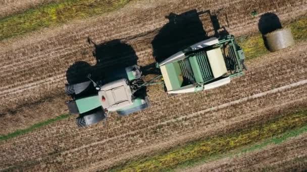 Aérien : tracteur ramasser le foin en balles par une journée chaude ensoleillée en été.