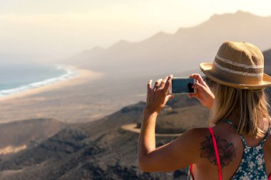 Coffee, İspanya: 2020 Ekim: Sarışın Kız Fuerteventura, İspanya 'daki Coffee Plajları' nın manzarasına fotoğraf çekti.