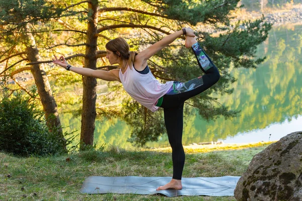 Kadın ormanda tek başına yoga yapıyor. Arka plan aktivitesi. Genç çekici Asyalı kadın yoga yapıyor. Egzersiz yapıyor..