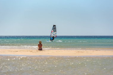 Sotavento, Fuerteventura, İspanya: 8 Ekim 2020: Yazın İspanya 'da Fuerteventura, Playa de Sotavento' da rüzgar sörfü öğrenen adam.
