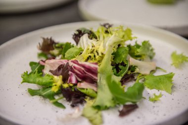 Beyaz tabakta sebze eşliğinde..