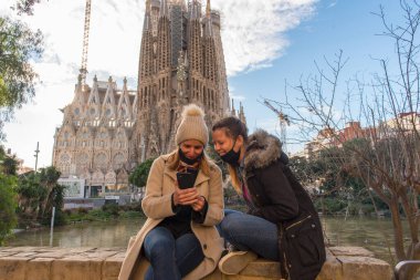 Barselona, İspanya: 30 Aralık 2020: Kutsal Aile 'nin Basicila ve Expiatory Kilisesi' ndeki genç kadınlar, gün batımında Sagrada Familia olarak bilinirler..