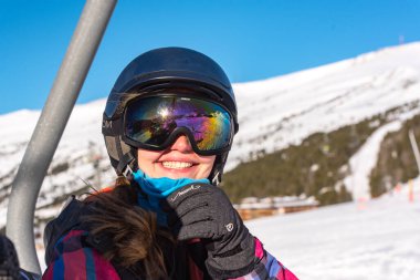 Pas de la Casa, Andorra: 3 Ocak 2021: Covid19 saatine göre Andorra 'daki Grandvalira kayak merkezinde Pireneler' de kayak yapan genç bir kadın