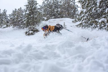 Covid19 saatine göre Andorra 'daki Grandvalira kayak merkezinde Pireneler' de kayak yapan genç adam..