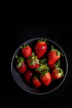 Arka planda siyah çilekler.