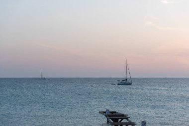 Fromentera, İspanya: 2021 Haziran: İspanya 'nın Formentera adasındaki Ses Illetes plajında gün batımında tekneler.