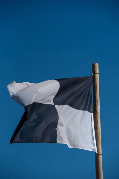 西班牙福门特拉岛上E 阿基纳海滩上的黑白旗帜被检查过 — 图库照片