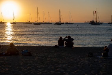 Formentera, İspanya: 23 Haziran 2021: Gençler Formetera 'da 2021 yazında Cala Saona' da günbatımının keyfini çıkarıyorlar.