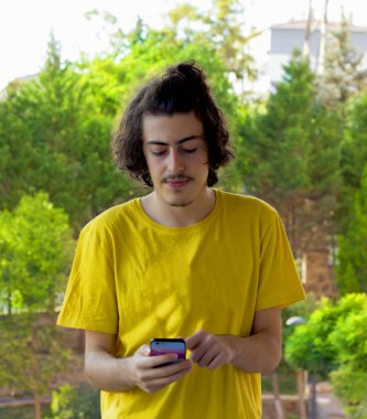 Mutlu genç adam cep telefonuyla selfie çekiyor.