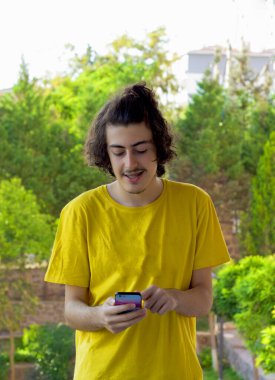 Mutlu genç adam cep telefonuyla selfie çekiyor.