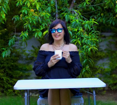 Bahçede güneş gözlüklü güzel bir kadın.