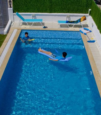 Mutlu ikizler yüzme havuzunda iyi eğlenceler.