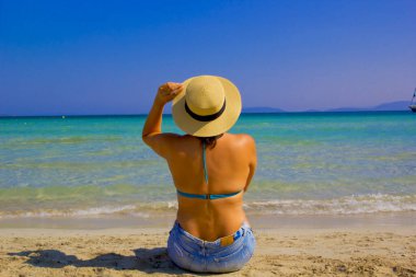 Türkiye plajında şapkalı ve bikinili bir kadın.