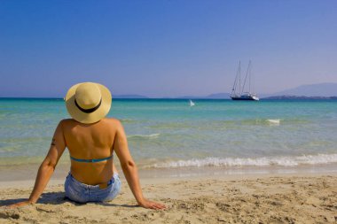 Türkiye plajında şapkalı ve bikinili bir kadın.