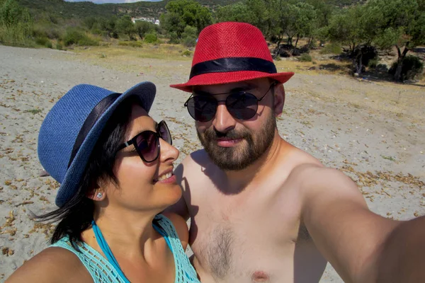  Plajda şapkalı mutlu bir çiftin portresi.