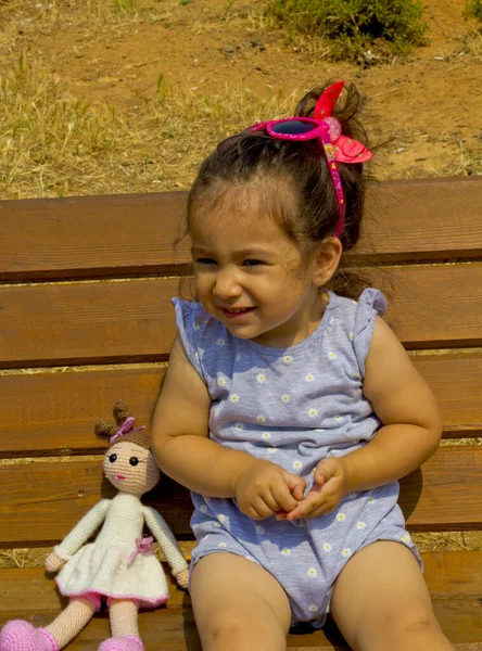 Felice Bambina Con Una Bambola Sorridente Alla Macchina Fotografica — Foto Stock