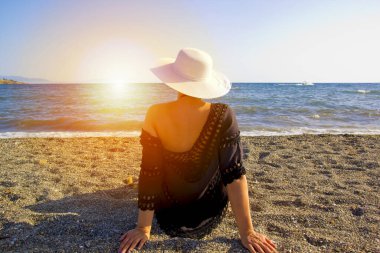 Yazın kumsalda beyaz şapkalı güzel bir kadın.