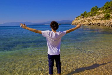 Yazın sahilde duran genç adam.