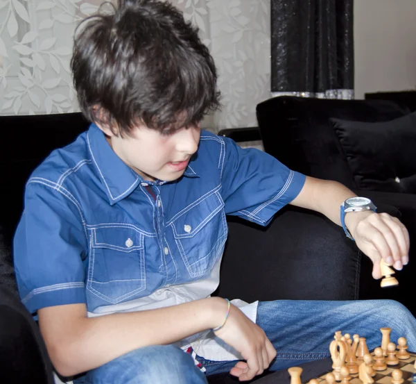 O rapaz está a jogar xadrez — Fotografia de Stock