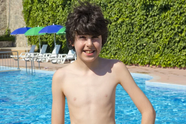 Happy boy is have fun in the swimming pool — Stockfoto