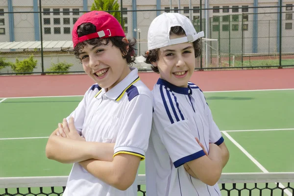 The boys are looking to the camera in the tennis court — 图库照片