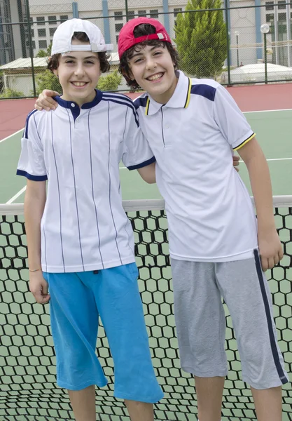 Rapaz feliz está no campo de ténis — Fotografia de Stock