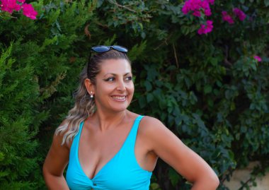  Bahçede kameraya gülümseyen güzel bir genç kadının portresi.