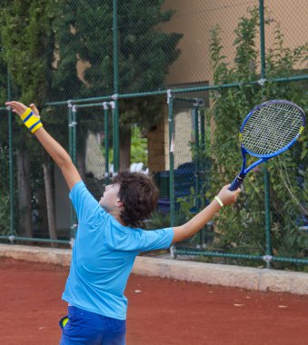 Çocuk tenis oynuyor