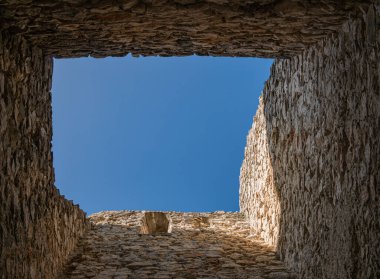 Gökyüzü manzaralı çatısı olmayan açık bir kale kulesi.