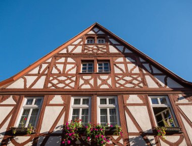 Pencerenin önünde çiçekli, yarı ahşap güzel bir evin kapısı.