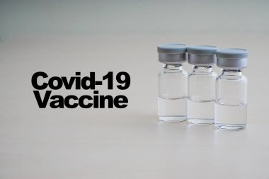 COVID - 19 VACCINE metin ahşap arka planda şişe. Coronavirus veya Covid-19 Aşı Konsepti