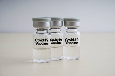 COVID-19 VACCINE metin ve ahşap arka planda şişeler. Coronavirus veya Covid-19 Aşı Konsepti