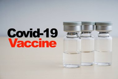 COVID - 19 VACCINE metin ahşap arka planda şişe. Coronavirus veya Covid-19 Aşı Konsepti