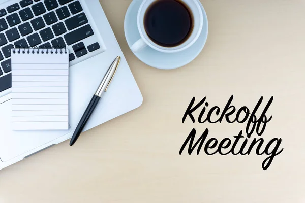 KICKOFF Dolma kalem, not defteri, dizüstü bilgisayar ve bir fincan kahveyle ahşap zemin üzerinde toplantı metni. İş ve kopyalama alanı kavramı