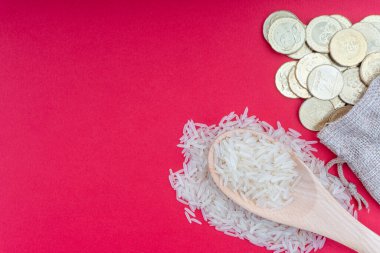 Kırmızı arka planda bozuk para ve pirinç. Zeka kavramı. Zekat, bir sadaka verme şeklidir. 