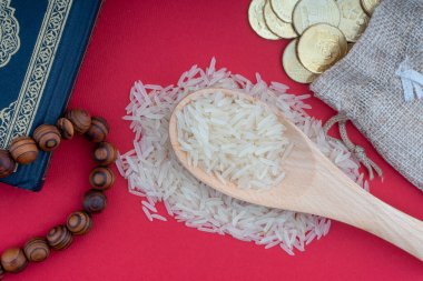 Kutsal Kur 'an, madeni paralar, tespih ve pirinç. Zeka kavramı. Zekat, bir sadaka verme şeklidir. 