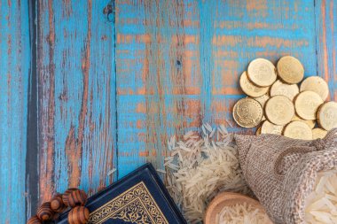 Kutsal Kur 'an, madeni paralar, tespih ve pirinç. Zakat ve Boşluk Kopyala. 